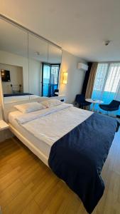 Orbi city mia luxury studio في باتومي: غرفة نوم بسرير كبير ومرآة كبيرة