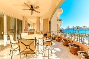 a patio with a table and chairs and the ocean at Villa La Estancia in Cabo San Lucas