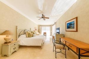 a bedroom with a bed and a desk and a ceiling fan at Villa La Estancia in Cabo San Lucas +58 photos