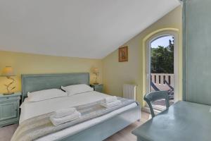a bedroom with a bed and a table and a window at Villa Margitta Mit Pool, Tennisplatz Und Meerblick in Drasnice +30 photos