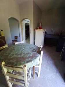 a kitchen with a table and chairs and a refrigerator at Lugar de descanso e muito verde praia e lagoa Araruama in Araruama