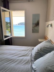 Un dormitorio con una cama con vista al mar. en Cap Morgat à l'écho des vagues, en Crozon