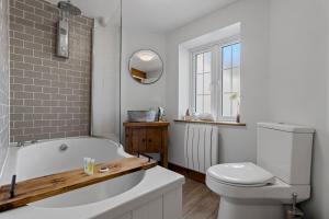 a bathroom with a white tub and a toilet at Angler's Cottage - Short Stays UK Ltd in Bridford +36 photos