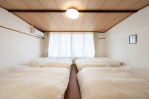 three beds in a room with a window at Casa G,S, - Vacation STAY 52576v in Osaka +22 photos