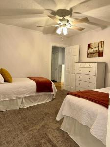 a bedroom with two beds and a ceiling fan at Cozy Bungalow 3bdrm 2 and a half bath Hot Tub in Little Rock +19 photos