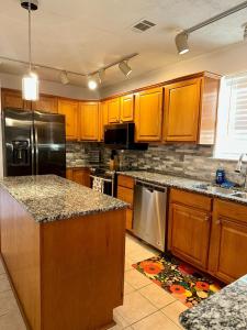 a kitchen with wooden cabinets and stainless steel appliances at Cozy Bungalow 3bdrm 2 and a half bath Hot Tub in Little Rock