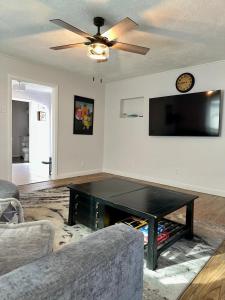a living room with a coffee table and a ceiling fan at Cozy Bungalow 3bdrm 2 and a half bath Hot Tub in Little Rock