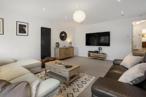 a living room with two couches and a flat screen tv at Evergreen Eco House - Allocated parking, Ancillary accommodation in Ripon