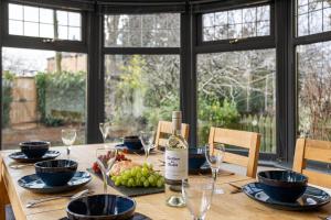 a wooden table with a bottle of wine on it at Evergreen Eco House - Allocated parking, Ancillary accommodation in Ripon