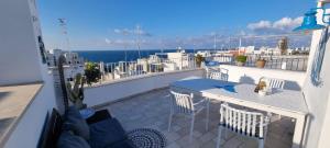 a balcony with a table and chairs and the ocean at Bella Vista Città Vecchia in Polignano a Mare