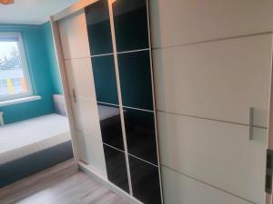 a closet with glass panels in a room at Piąteczka in Pniewy +3 photos