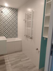 a bathroom with a shower and a tub and a sink at Piąteczka in Pniewy