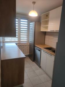 a kitchen with white cabinets and a counter top at Piąteczka in Pniewy