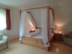 a bedroom with a canopy bed with two lamps at Ferienhaus Zotter in Feldbach