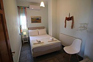 een kleine slaapkamer met een bed en een stoel bij VILLA RELAX in Skala Kallirakhis