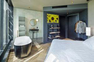 ホーフトドルプにあるThe Florian Amsterdam Airport, WorldHotels Craftedのベッドルーム(ベッド1台、シンク、鏡付)
