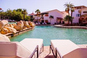 una piscina con mesas y sillas en un resort en Los Cabos Golf Resort, Trademark Collection by Wyndham, en Cabo San Lucas