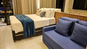 a bedroom with a bed and a couch at Flat Luxo 104A Malia em Muro Alto Porto de Galinhas in Ipojuca +88 photos