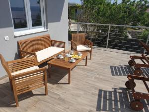 3 sedie in legno e un tavolo su un patio di Wohnung In Cesarica Mit Privater Terrasse a Cesarica
