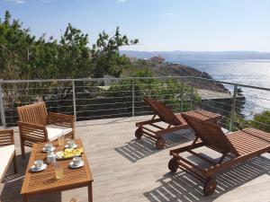 patio con 2 sedie, tavolo e vista sull'acqua di Wohnung In Cesarica Mit Privater Terrasse a Cesarica