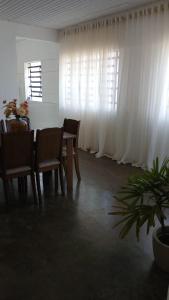 a dining room with a table and chairs and curtains at Apartamento Central in Triunfo +6 photos