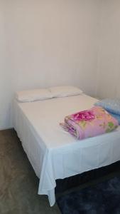 a white bed with a blanket on top of it at Apartamento Central in Triunfo