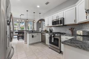 cocina grande con armarios y electrodomésticos blancos en Skyblue Villas, en Haines City