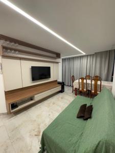 a bedroom with a television and a bed and a table at Seu apartamento frente mar in Vila Velha