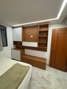 a bedroom with a bed and a wooden cabinet at Seu apartamento frente mar in Vila Velha +5 photos
