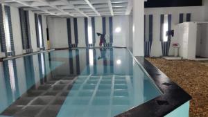 a swimming pool with a person standing in the middle of it at Akkarai Beach Luxury Beach Villa in Chennai