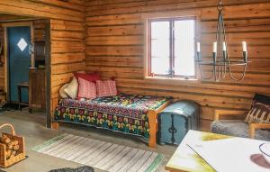 オーケシュバーリアにある1 Bedroom Cozy Home In Åkersbergaのログキャビン内のベッド1台が備わる客室です。