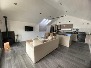 a living room with a white couch and a kitchen at Modo Villa Refugio in Villa La Angostura +8 photos
