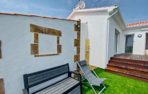 a bench sitting outside of a house with a porch at Villa Avec Piscine Privée in Saint-Jean-de-Monts +24 photos