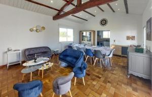 a dining room with a long table and blue chairs at Villa Avec Piscine Privée in Saint-Jean-de-Monts