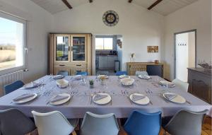 a dining room with a table and chairs and a clock at Villa Avec Piscine Privée in Saint-Jean-de-Monts