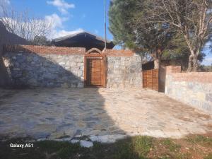 een stenen huis met een deur en een stenen muur bij Ali dede kamp karavan bungalow in Kuşadası