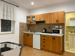a kitchen with wooden cabinets and a microwave at Vanessa apartments in Bešeňová