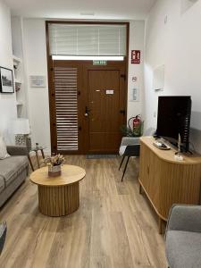 un soggiorno con un divano e una scrivania con una televisione di Alcazaba II tourist apartment a Badajoz