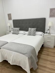 una camera da letto con un letto grande con una grande testiera di Alcazaba II tourist apartment a Badajoz Altre 8 foto