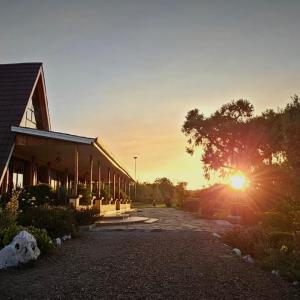 a building with the sun setting in the background at Juniper Park Resort in Nyahururu