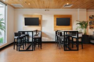 a bar with black stools and televisions in a room at Holiday Inn Express Tegucigalpa by IHG in Tegucigalpa