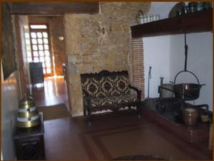 - un salon avec une cheminée dans un bâtiment en pierre dans l'établissement Hôtel du Sablar, à Mont-de-Marsan