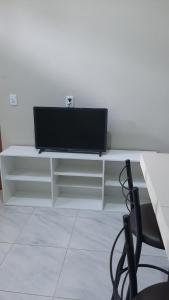 a flat screen tv sitting on a white entertainment center at Kitipê Arretado da Peste in Aquiraz