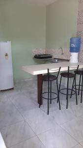 a kitchen with a table with chairs and a sink at Kitipê Arretado da Peste in Aquiraz