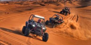 two atvs driving through the sand in the desert at Grand Plaza Nouakchott in Nouakchott