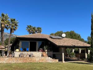 a house with a tile roof and palm trees at LO CLAUSTRE DEL DELTA- LUX FINCA in Delta del Ebro - FINCA PRIVADA -NO HAY NINGUN SERVICIO HOTELERIA- SOLO ALOJAMIENTO in Sant Carles de la Ràpita