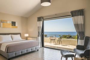 a bedroom with a bed and a view of the ocean at Villa Astoria Exclusive luxury villa in Svoronata with breathtaking views and private grounds in Kefallonia +49 photos