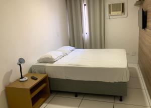 ein kleines Schlafzimmer mit einem Bett und einem Nachttisch in der Unterkunft Apto 250m da praia em Ponta Verde I Piscina I Garagem 709 in Maceió + 28 Fotos