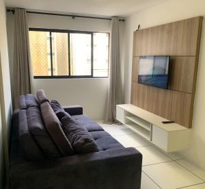 ein Wohnzimmer mit Sofa und Fernseher in der Unterkunft Apto 250m da praia em Ponta Verde I Piscina I Garagem 709 in Maceió