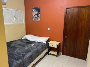 ein kleines Schlafzimmer mit einem Bett und einer Holztür in der Unterkunft Suite el Angel #2 in Tuxtla Gutiérrez